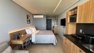 a hotel room with a bed and a desk at Acqua Tambaú Luxury Flat 100 meters from the sea in João Pessoa