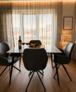 a dining room with a glass table and chairs at Vista Visoko Apartants in Visoko