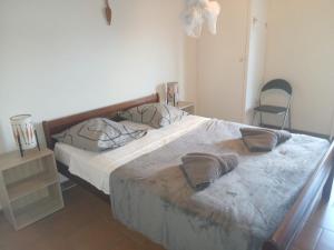 a bedroom with a large bed and a chair at Villa creole in Le Diamant