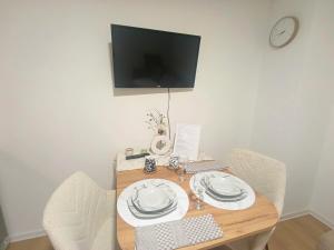 a dining room table with two chairs and a television at VracarHouse in Vračar (historical)