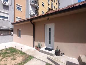 a house with a white door and some plants at VracarHouse in Vračar (historical)