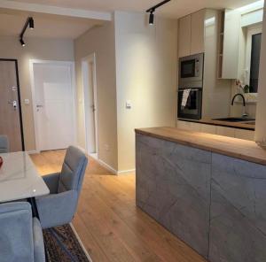 a kitchen with a counter and a table and chairs at Vista Visoko Apartants in Visoko +15 photos
