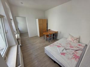 a small bedroom with a bed and a table at Ferdimesse Apartments in Cologne