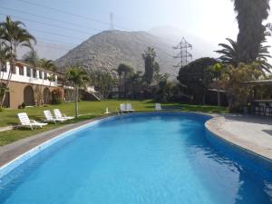 a large swimming pool with a mountain in the background at El Angolo Chosica in Nicolas de Pierola