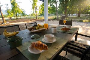 a table with a breakfast of croissants and orange juice at Holiday Home Ari in Lički Ribnik