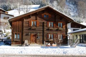 a wooden house with snow in front of it at Montafonerhaus in Schruns