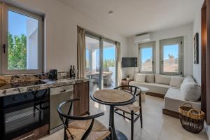 a kitchen and living room with a couch and a table at Evgoro Luxury Suites in Agia Galini