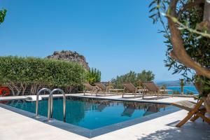 a swimming pool with lounge chairs next to a resort at Evgoro Luxury Suites in Agia Galini