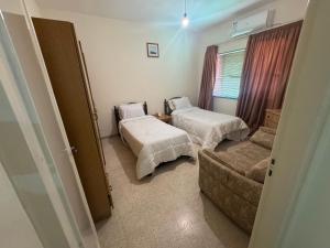a small room with two beds and a couch at شقق الخامسه الفاخرة Al Amer Luxury Apartments in Aqaba