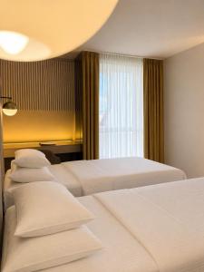 a hotel room with three beds and a window at Hotel Bosna Banja Luka in Banja Luka +24 photos