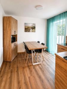 a kitchen and dining room with a wooden table and chairs at CalmApart Firmenrechnung mit MwSt in Kleinkötz
