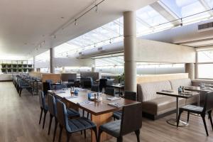 a dining room with tables and chairs and windows at Hotel Murano in Tacoma