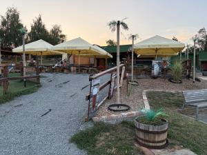 a restaurant with yellow umbrellas and tables and chairs at Karavan u přehrady in Prostějov