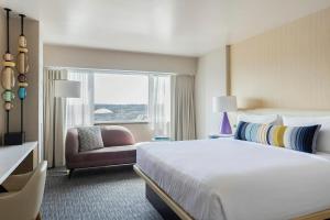 a hotel room with a bed and a chair and a window at Hotel Murano in Tacoma +130 photos