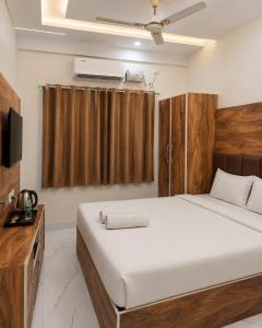 a bedroom with a large bed and a television at Hotel jetway in Muthugadahalli