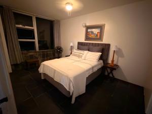ein Schlafzimmer mit einem Bett mit weißer Bettwäsche und einem Fenster in der Unterkunft Ocean rest in Scottburgh