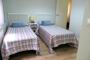 two beds sitting next to each other in a bedroom at Viv. Turística Museo del Comercio in Salamanca