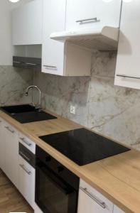 a kitchen with white cabinets and a black sink at Polna 16 in Mrągowo