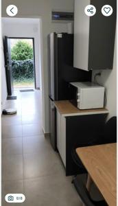 a kitchen with a counter and a door with a table at Polna 16 in Mrągowo +4 photos