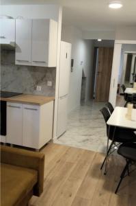 a kitchen with white cabinets and a table and chairs at Polna 16 in Mrągowo