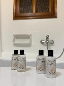 three bottles sitting on a counter in a bathroom at Petalidi seaside Retreat in Petalidi +26 photos