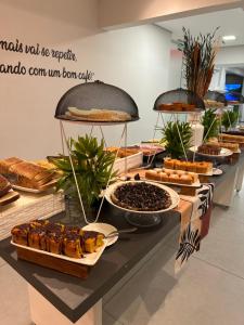 a buffet of bread and pastries on a table at Express Floripa Residence in Florianópolis