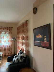 a living room with a couch and a painting on the wall at Family-friendly in Pogradec