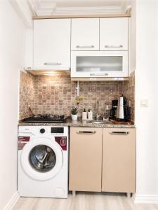a white kitchen with a washer and dryer at Askin Suits Canakkale in Çanakkale +14 photos