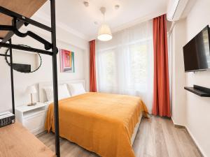 a bedroom with a bed and a flat screen tv at Askin Suits Canakkale in Çanakkale