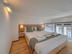 a bedroom with a large white bed with towels on it at FLATSHARING - SPADARI Duomo Suites in Milan