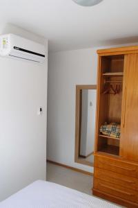 1 dormitorio con 1 cama y armario con espejo en Apartamento Completo no Jardim da Barra - Barra Olímpica, en Río de Janeiro