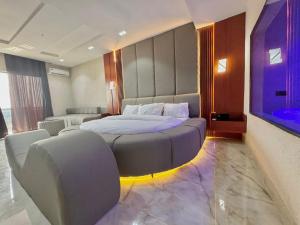 a bedroom with a large bed and two chairs at One One B Luxury Hotel in Asaba