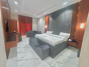 a hotel room with a bed and a couch at One One B Luxury Hotel in Asaba