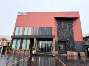 a red and black building in the rain at One One B Luxury Hotel in Asaba +5 photos