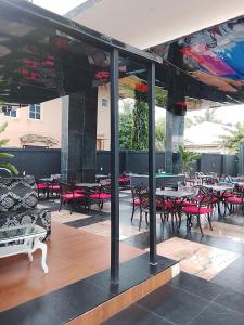 an outdoor patio with tables and chairs and tables and chairs at One One B Luxury Hotel in Asaba