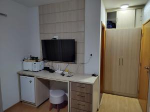 a room with a desk with a television on it at Serra Negra Piemonte Flat Paz e Lazer Num Só Lugar in Serra Negra