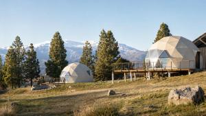 two domes on a hill with mountains in the background at Nawal Glamping - Domos in Trevelín
