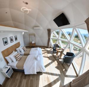a bedroom with two beds and a large window at Nawal Glamping - Domos in Trevelín