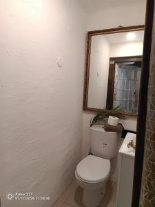 a bathroom with a toilet and a mirror at Casa do Adro in Corte do Gafo de Cima