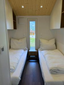 two beds in a small room with a window at Häuschen am Traunig in Hermagor