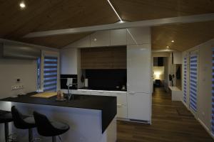 a kitchen with a black and white counter and chairs at Häuschen am Traunig in Hermagor