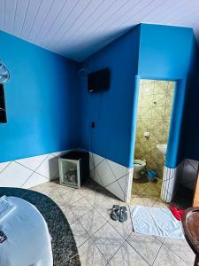 a room with a blue wall and a tv in a room at A2 suites Unid Sofia in Jataí