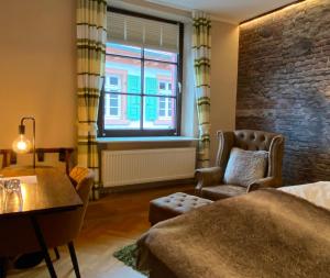 a bedroom with a bed and a chair and a window at Zum Burggraf in Neuleiningen