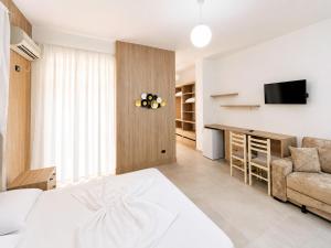 a bedroom with a bed and a couch and a television at Hotel Mjeshtri in Shëngjin +8 photos