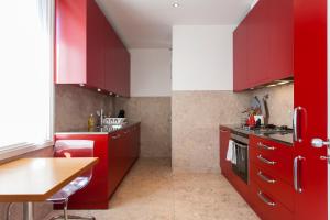 a kitchen with red cabinets and a wooden table at Apartment Carmo in Lisbon