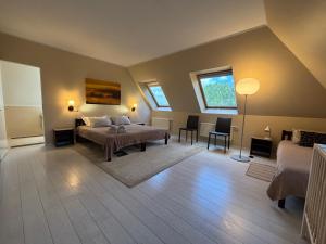 a bedroom with a bed and a table and two windows at Jaunkrastmaļi in Kandava