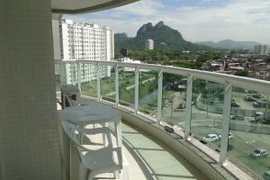 balcón con silla y vistas a la ciudad en Apartamento Completo no Jardim da Barra - Barra Olímpica, en Río de Janeiro