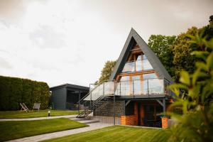 a glass house with a gambrel roof at Apartamenty Labuda in Garcz