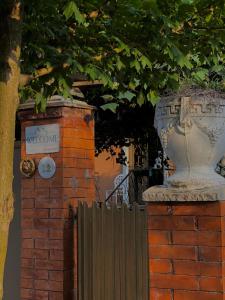 a brick wall with a vase next to a fence at SeGi Garden Home in Khobi