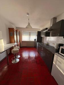 a kitchen with a red tile floor and a kitchen with counters at Ferienwohnung Freudenberg in Freudenberg am Main